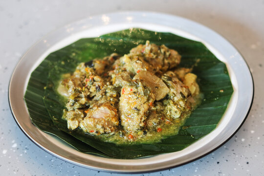 A plate of Babi Bulu or Babi Buluh, a traditional Manadonese dish featuring tender pork marinated in aromatic local spices and slow-cooked inside a bamboo stalk, served on a plate.