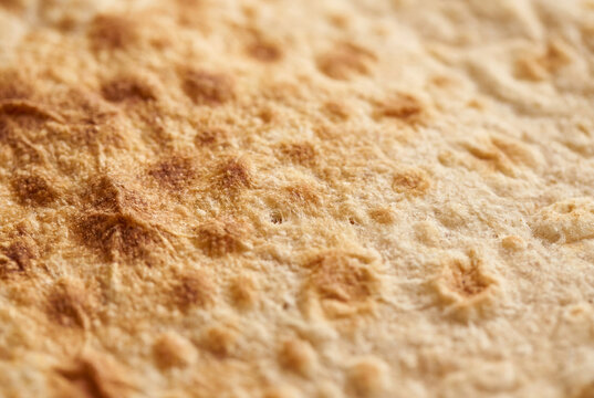 Close up of armenian lavash flatbread showing golden brown toasted spots and textured surface