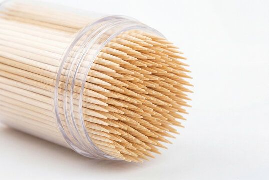Clear cylindrical plastic holder tightly packed with natural bamboo toothpicks