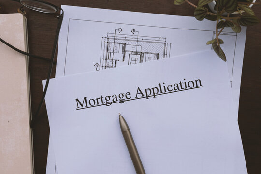 Printed home loan application form with house floor plans and eyeglasses on a table.