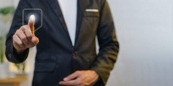 Businessman in formal suit touching virtual interface with finger outdoors