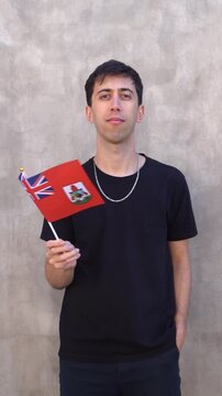 Man waving the Bermudian flag in slow motion. Vertical shot.