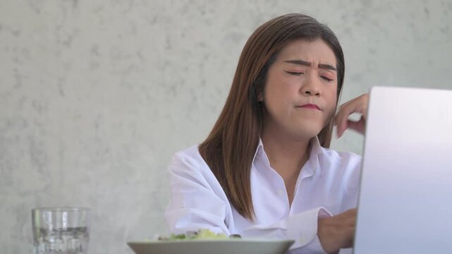 Stressed Thai Transgender Businesswoman Using Laptop Typing with Salad Bowl