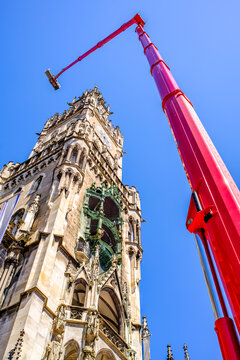 Construction equipment is positioned in a courtyard with safety cones and tools visible, ideal for maintenance tasks in an urban environment