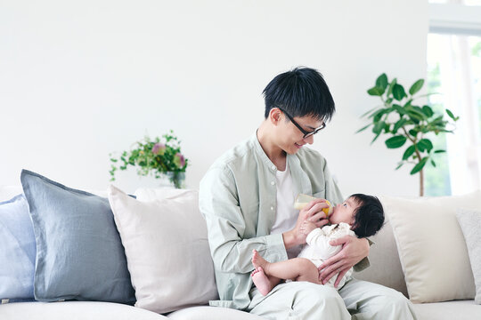 ミルクをあげる父親と赤ちゃん