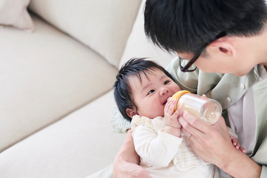 ミルクをあげる父親と赤ちゃん