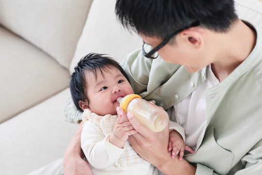 ミルクをあげる父親と赤ちゃん