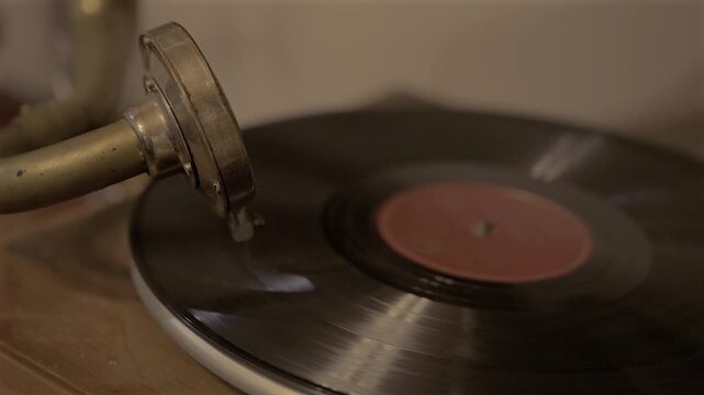 Horizontal 4K video of a vinyl record spinning on an antique gramophone with warm cinematic lighting and shallow depth of field.