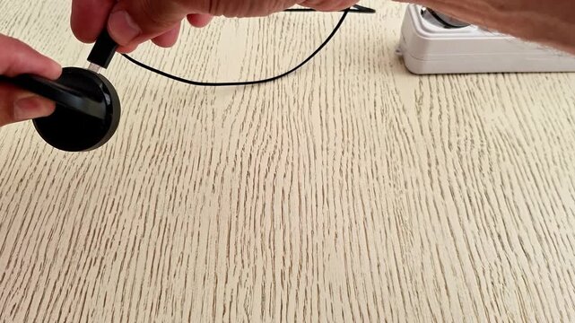 Modern smart watch charger plugged into the mains power outlet, providing a convenient charging solution for wearable technology and everyday electronic devices