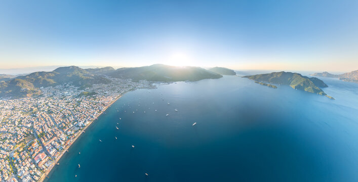 Marmaris, Turkey. Panoramic aerial view of city with sunrise behind mountains, coastline, yachts, marina and Cennet Island. Complete morning landscape. Aerial view.