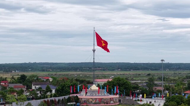 Drone captures the Hien Luong Bridge decorated with rows of Vietnamese flags, stretching across the Ben Hai River with settlements visible on both banks.