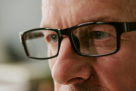 Close up of middle aged Caucasian man wearing eyeglasses, focusing in military hospital during treatment or recovery. Useful for veteran healthcare, medical support campaigns