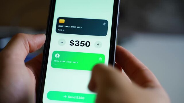Hands using mobile banking app on smartphone to send money transfer