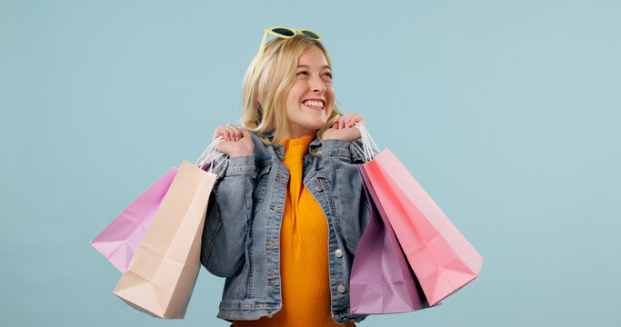 Retail, girl or excited with shopping bags in studio for clothing discount, clearance sale or space. Happy, shopper and designer products on blue background for fashion promo, boutique deal or gifts