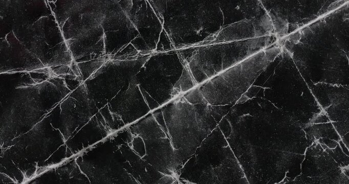 Rotating Crumpled Black Paper Texture. Glossy wrinkled paper with white crease lines and scuff marks rotates smoothly.