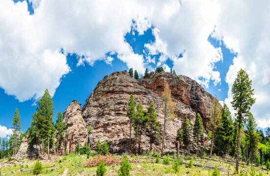 Large rock formation under a partly cloudy sky