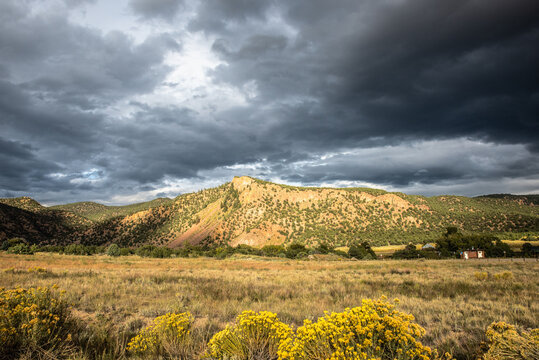 Storm clouds gather over a sunlit mountain ridge