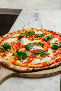 Freshly baked Margherita pizza from a pizzeria, isolated.