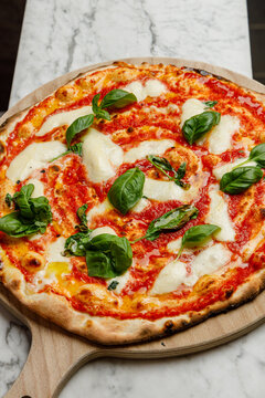Freshly baked Margherita pizza from a pizzeria, isolated.