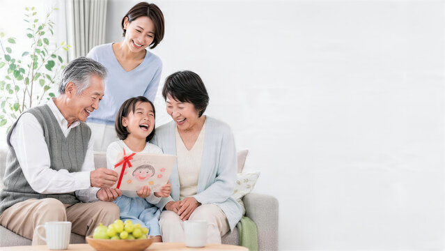 孫の手作りカードを囲んで笑う祖父母と母親