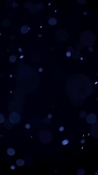 Blue Floating Particles on Dark Background. Soft glowing particles drift through darkness, creating an atmospheric abstract bokeh effect.