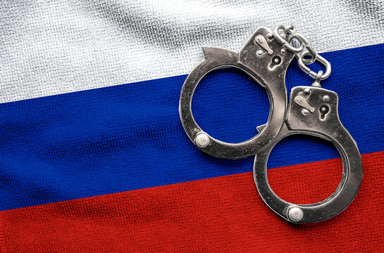 Flag of Flag of Russia and police handcuffs. Crime and offenses in country Concept

