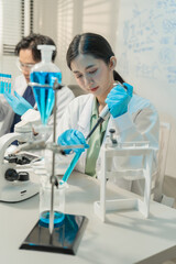 Fototapeta premium Woman researcher examining chemical solution sample in lab.
