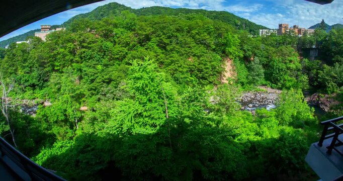 Jozankei Ryokan Room View Day Timelapse: Sunlight over Toyohira River Valley and Lush Green Mountains, Sapporo, Hokkaido, Japan - Wide Angle Shot