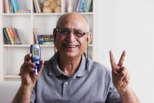 Old man with glucose meter gesturing