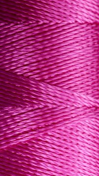 Pink Twisted Thread Texture. Macro view of tightly wound shiny fibers forming a dense diagonal pattern. Ideal for textile backgrounds.