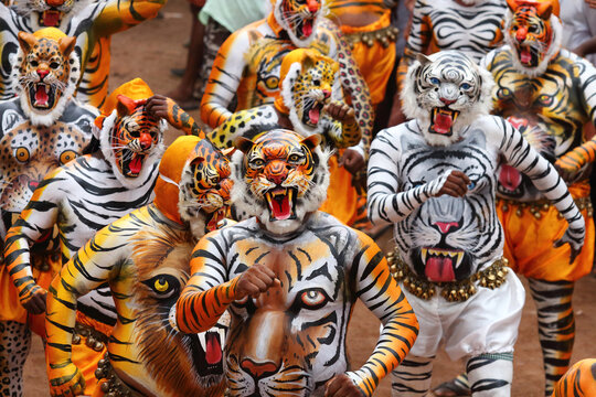 Tiger dance performers in vibrant tiger body paint and elaborate masks parade during the Onam festival in Thrissur, Kerala, India, celebrating a renowned traditional folk art