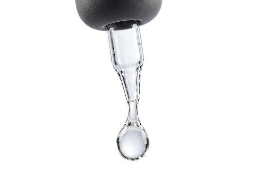 Clear liquid serum dropping from pipette.
