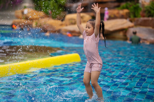 preschool child girl playing water splashing in swimming pool
