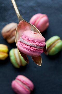 Pink macaron on a spoon