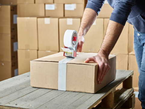 Worker closing package with package tape