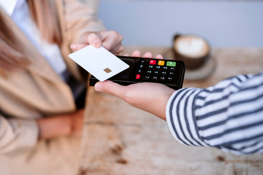Businesswoman paying through credit card to waiter at cafe
