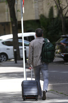 Viajero equipaje, maleta y mochila en calle de espaldas vacaciones 