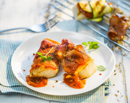 Grilled fish fillet with bacon, paprika marinade and herbs
