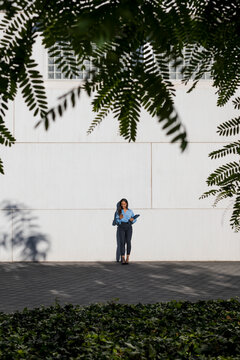 Businesswoman using smartphone, laptop bag
