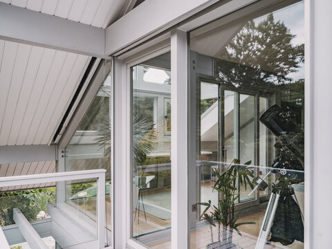 Modern timber frame villa with large windows and telescope