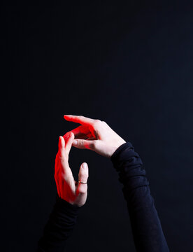 Hand reaching out with red light on black background