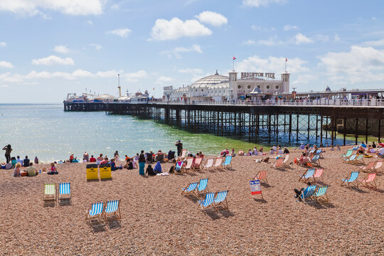 The sunny pebble beach features the famous Brighton Pier in summer