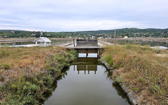 Symmetrical reflection of traditional wooden sluice gate in salt pan canal at Secovlje Salina, Slovenia