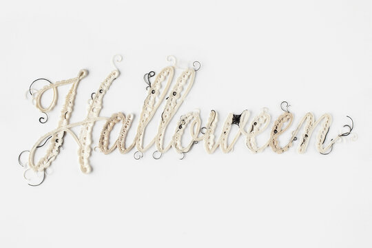 Halloween decorative text in elegant cursive script, rustic twine rope lettering for autumn holiday, handcrafted seasonal typography on white background