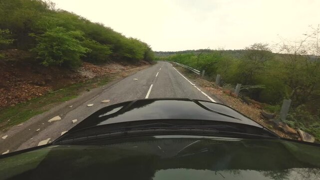 driving a car over the winding roads covered with forest of gwalior madhya pradesh