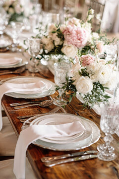 The table features white plates, silver cutlery, and elegant glassware, along with fresh flowers arranged in the center for a special gathering