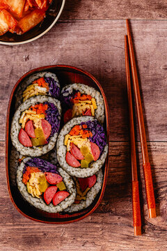 Colorful kimbap (or gimbap) with vegetables and sausage in a wooden box