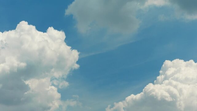 White clouds time lapse. Clouds running across the blue sky. 4k Timelapse of white clouds with blue sky background. Weather concept b roll shot.