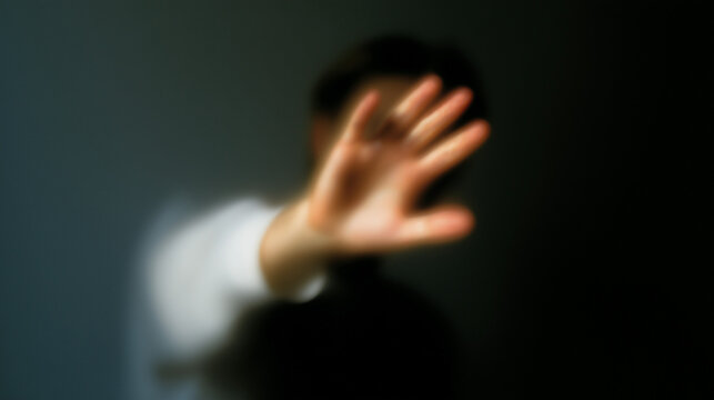 Minimalist conceptual photo of an extremely blurred person with an outstretched hand, representing psychological boundaries and self-defense
