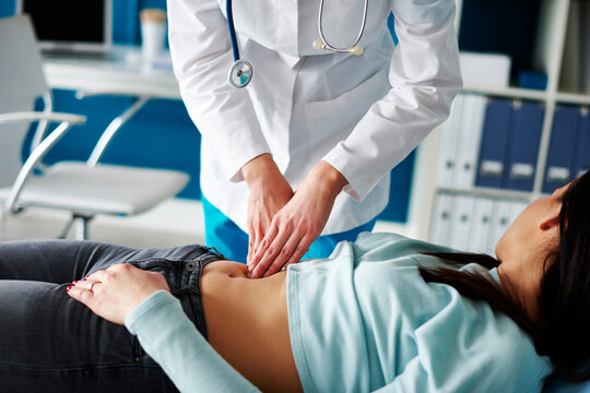 Doctor examining woman's stomach in medical practice